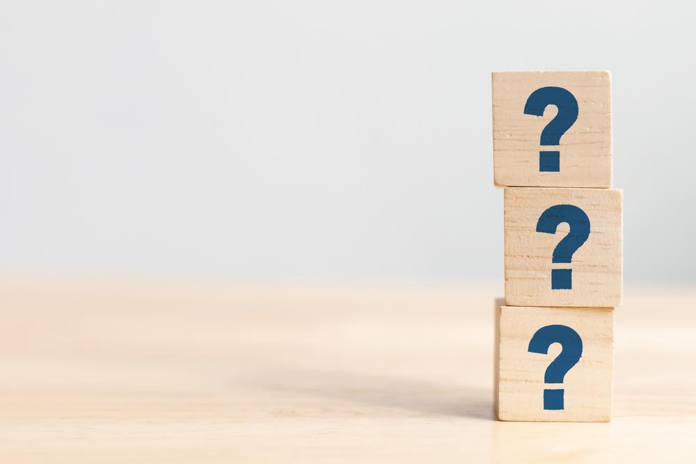 Wooden blocks, stacked with a question mark on each