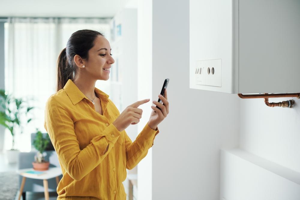 Woman making phone call next to boiler